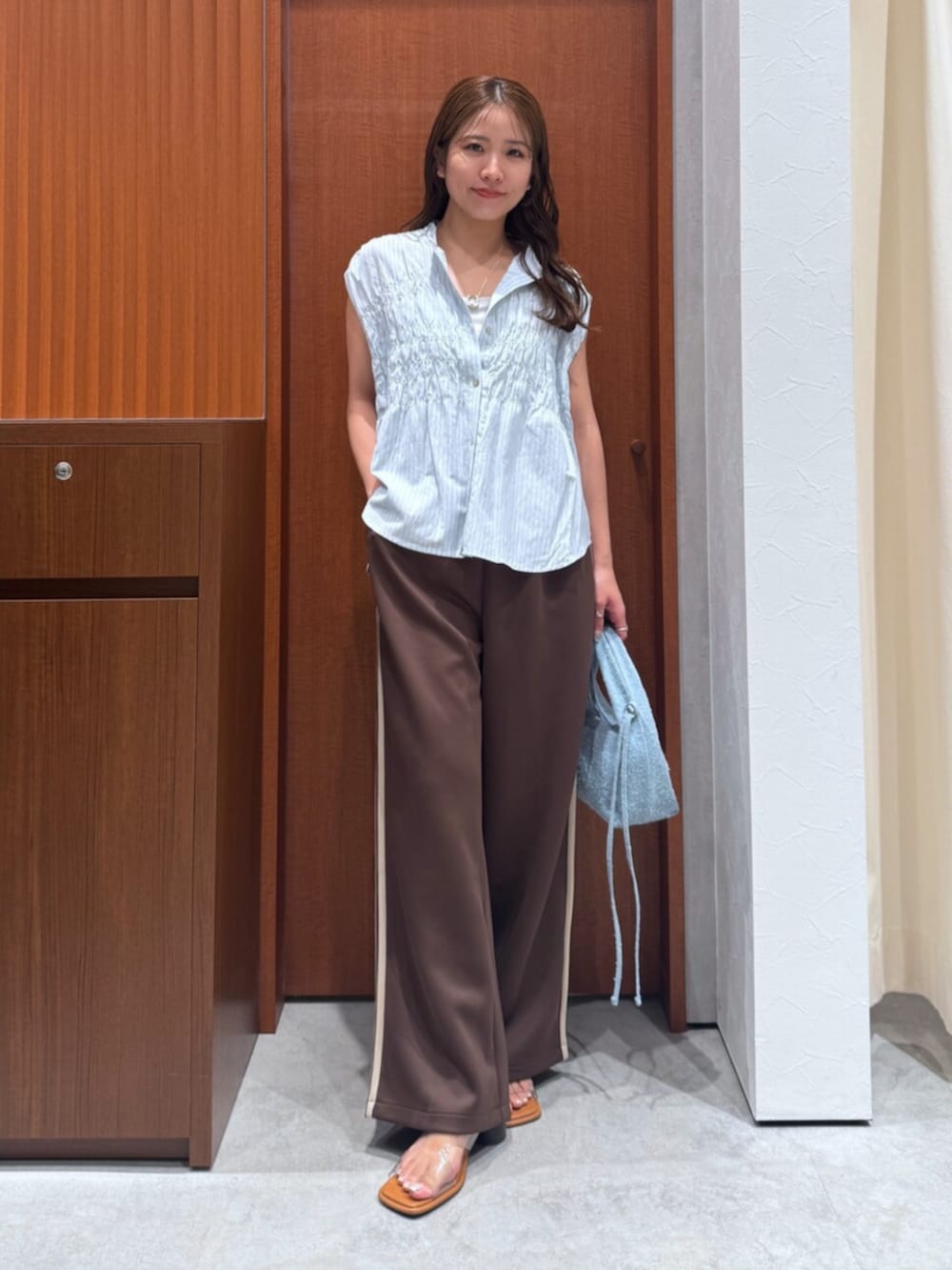 その他のサンダル、ブラウン系のその他パンツ、ブルー系のハンドバッグを着用したレディースの夏コーディネートの7枚目の写真