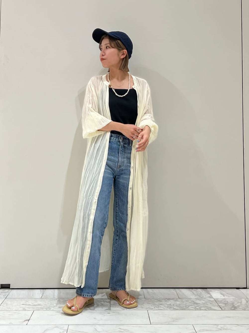 ブルー系のデニムパンツ、グリーン系のサンダル、ブラック系のキャミソールを着用したレディースの夏コーディネートの4枚目の写真