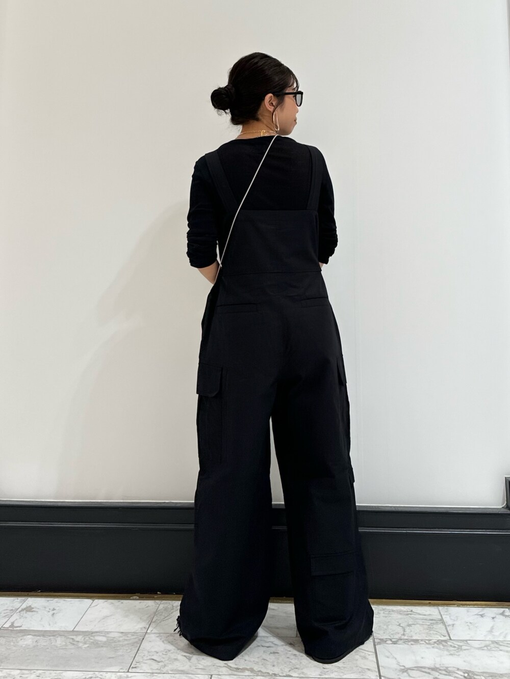 ブラック系のつなぎ/オールインワン、ブラック系のTシャツ/カットソー、ブラック系のサンダルを着用したレディースの冬コーディネートの5枚目の写真