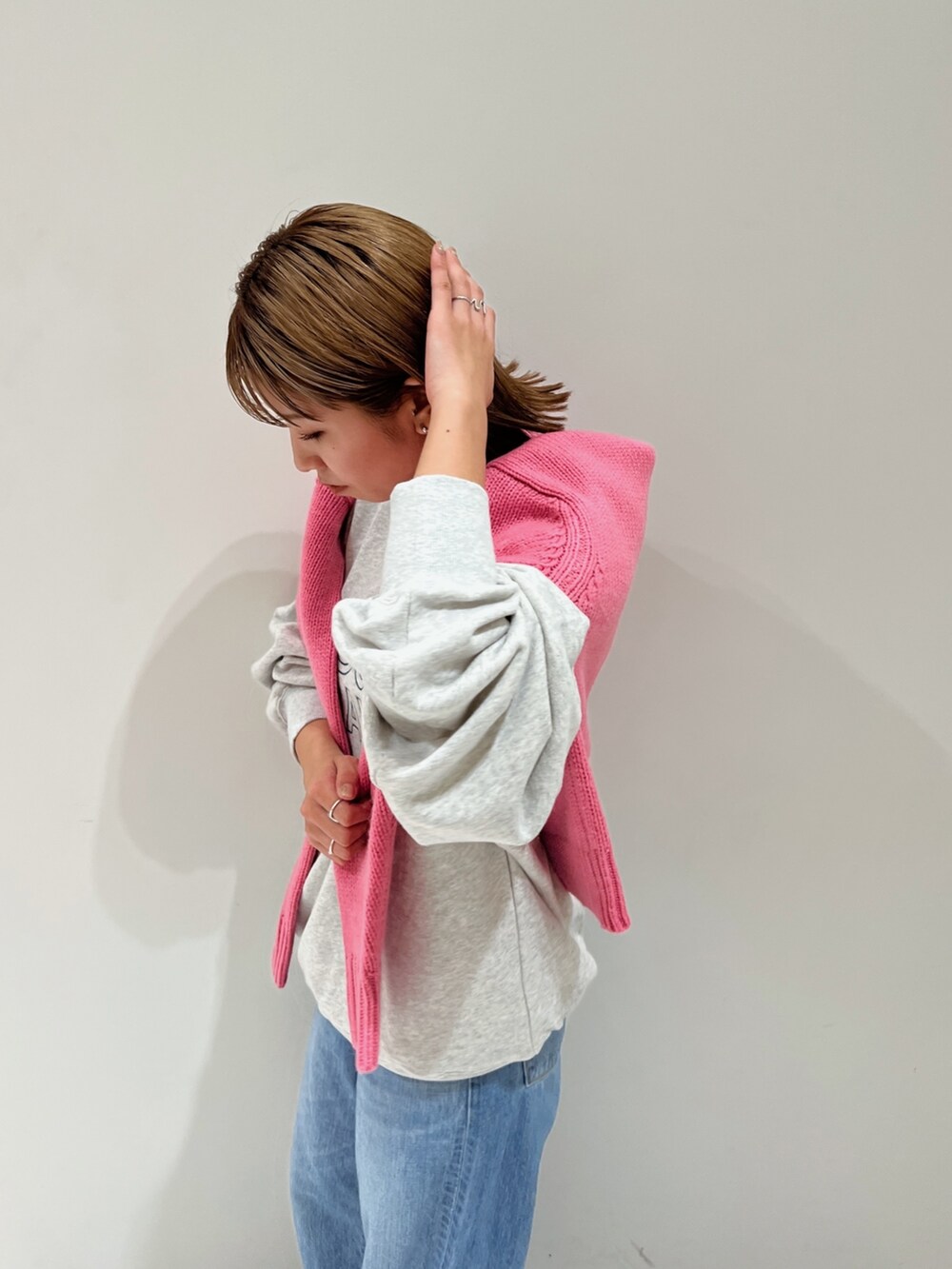 ピンク系のニット/セーター、グレー系のスウェット、ブルー系のデニムパンツを着用したレディースの秋コーディネートの8枚目の写真