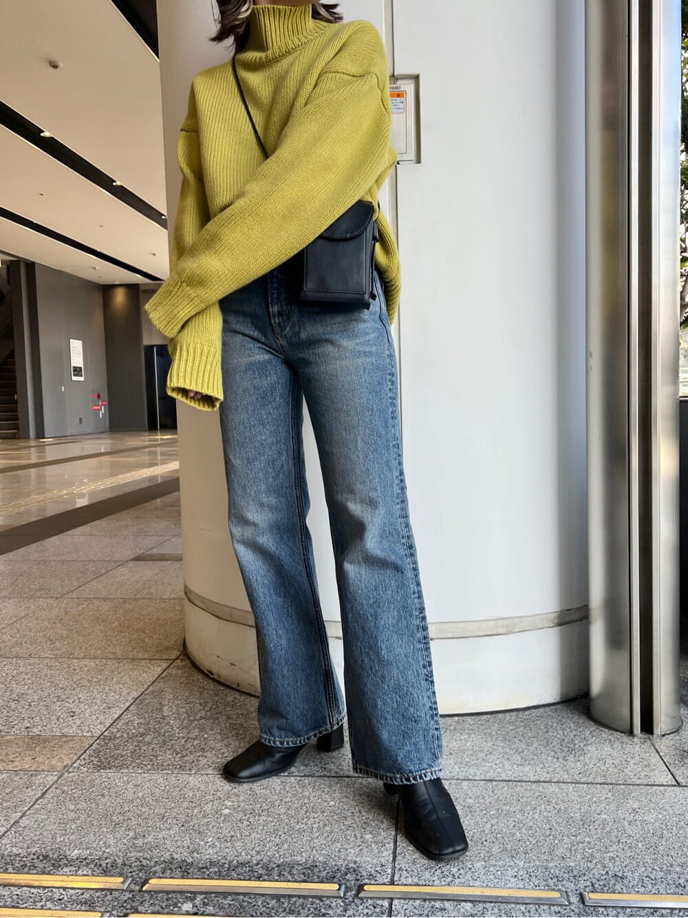 ブルー系のデニムパンツ、グリーン系のニット/セーターを着用したレディースの冬コーディネートの4枚目の写真