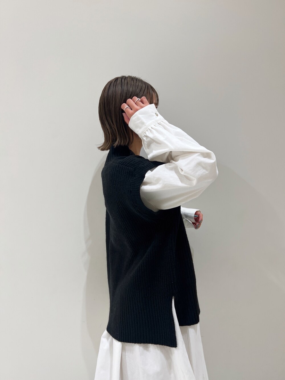 ブラック系のニット/セーター、ブラック系のワンピース、ブラック系のブーツを着用したレディースの冬コーディネートの6枚目の写真