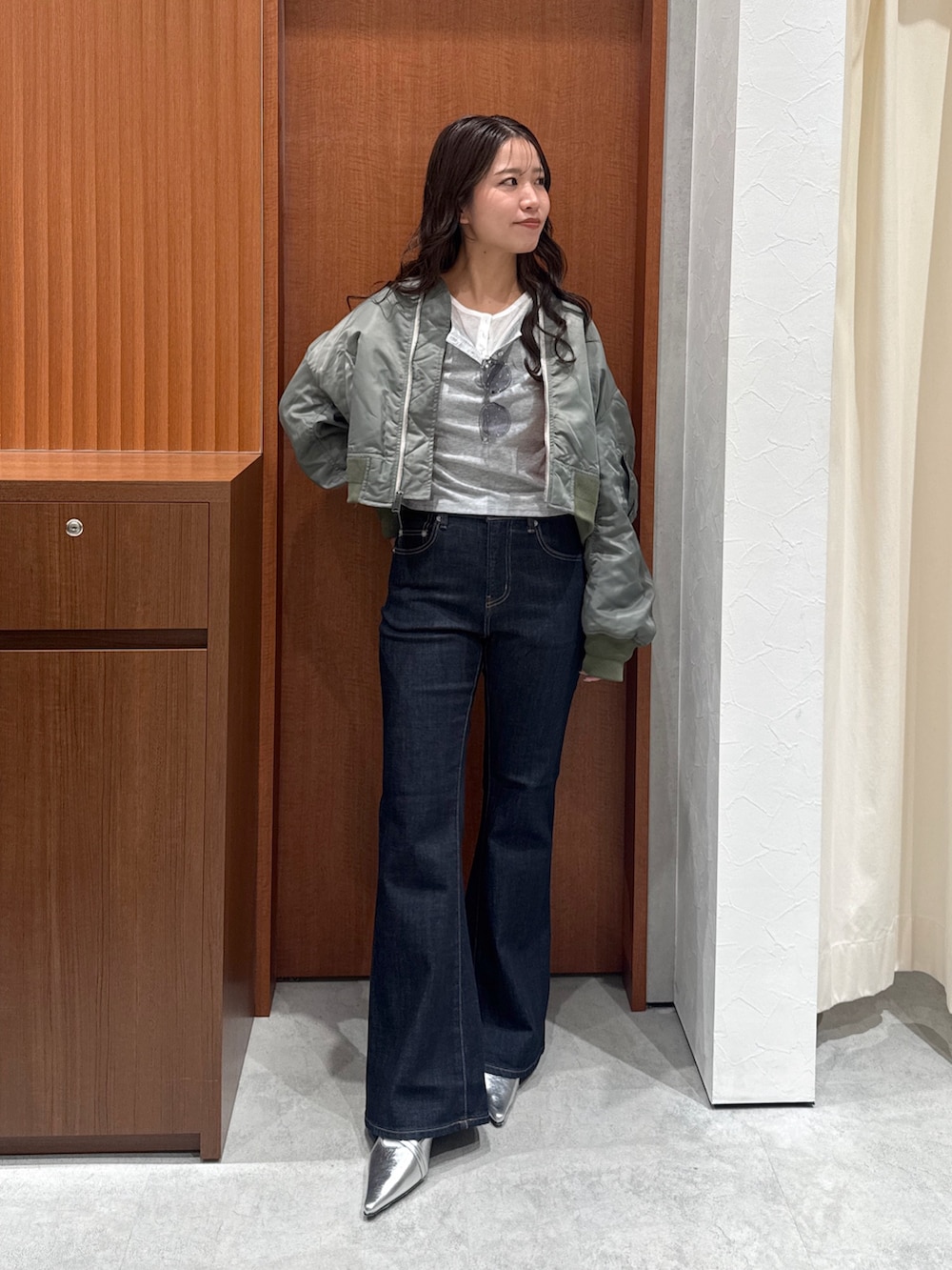 ブルー系のデニムパンツ、グレー系のTシャツ/カットソー、グリーン系のMA-1を着用したレディースの秋コーディネートの2枚目の写真