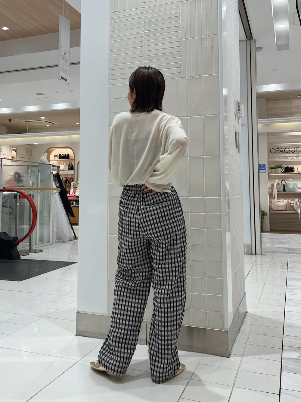 イエロー系のニット/セーター、イエロー系のパンプス、グレー系のその他パンツを着用したレディースの冬コーディネートの5枚目の写真