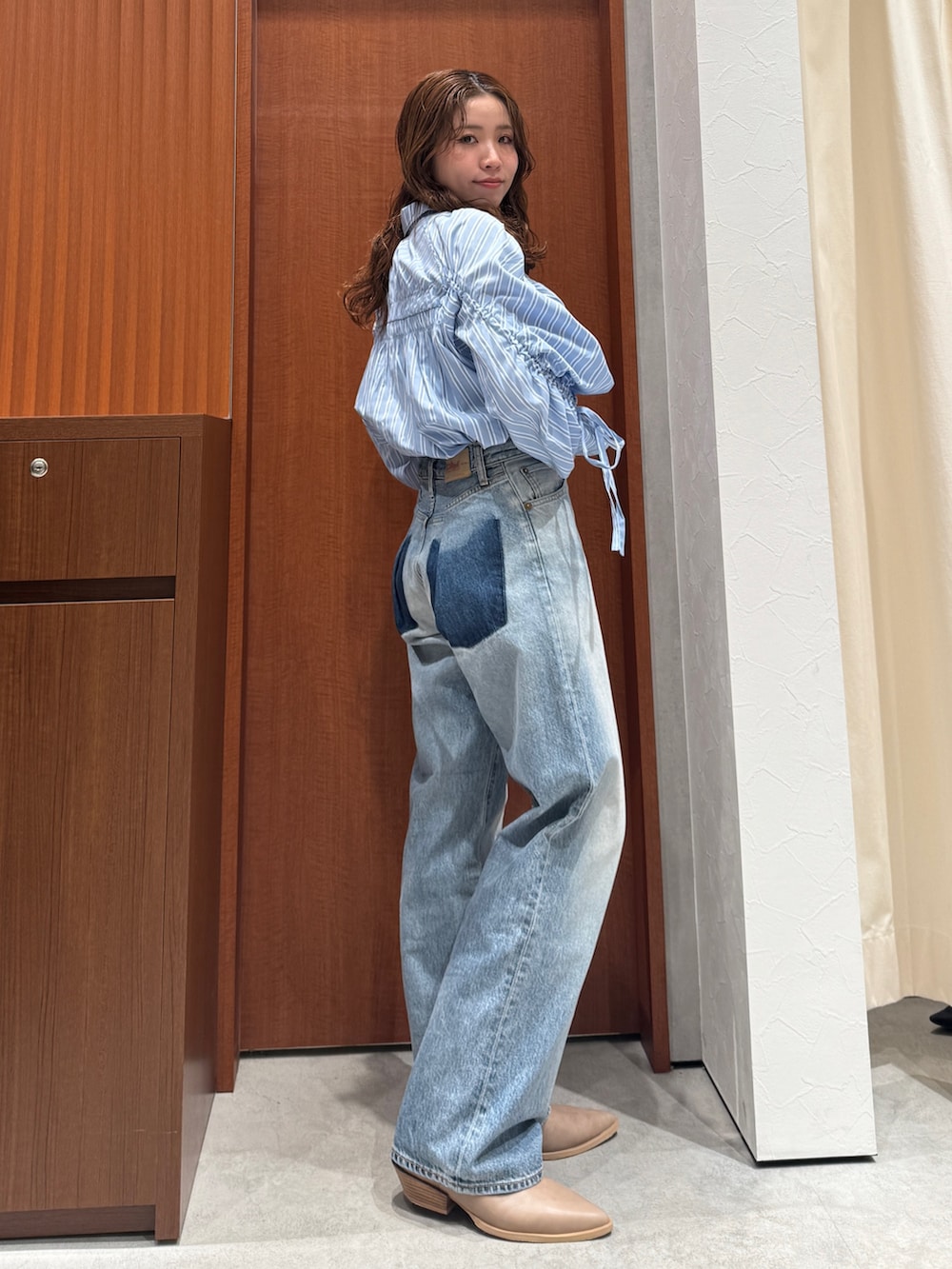 ブルー系のシャツ/ブラウス、ブルー系のデニムパンツ、ベージュ系のブーツを着用したレディースの春コーディネートの3枚目の写真