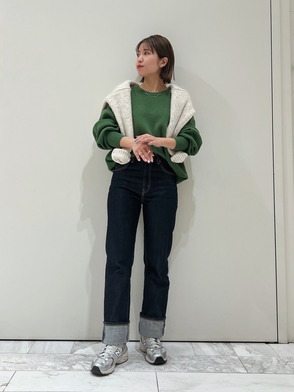 グリーン系のニット/セーター、ホワイト系のニット/セーターを着用したレディースの冬コーディネートの2枚目の写真