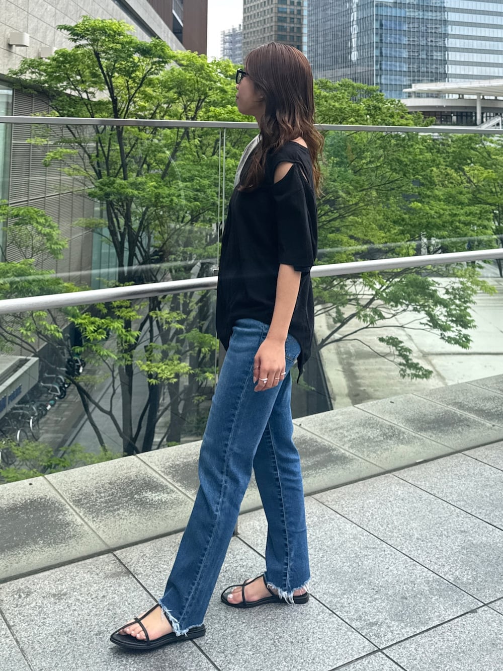 ブラック系のTシャツ/カットソー、ブルー系のデニムパンツを着用したレディースの春コーディネートの6枚目の写真