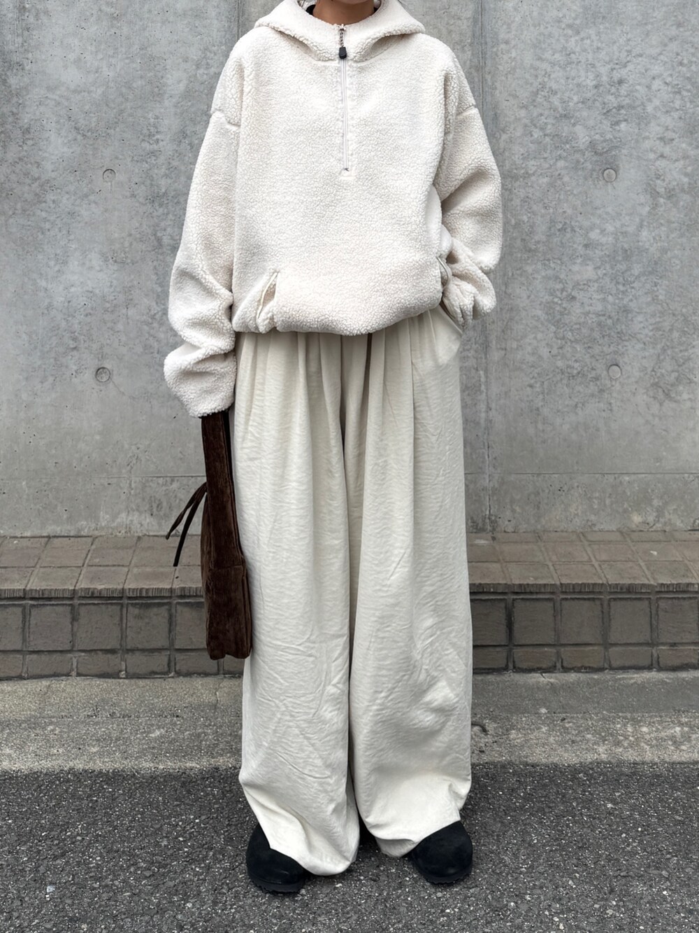 ホワイト系のパーカー、ホワイト系のその他パンツ、ブラウン系のハンドバッグを着用したレディースの秋コーディネートの3枚目の写真