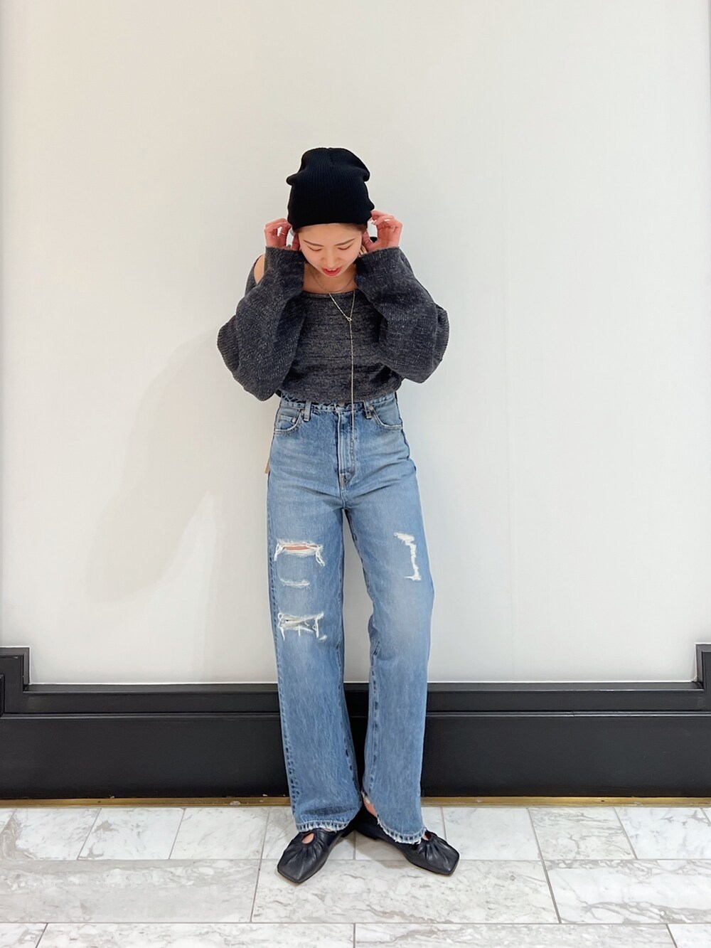 ブルー系のデニムパンツ、グレー系のニット/セーター、ブラック系のパンプスを着用したレディースの春コーディネートの6枚目の写真