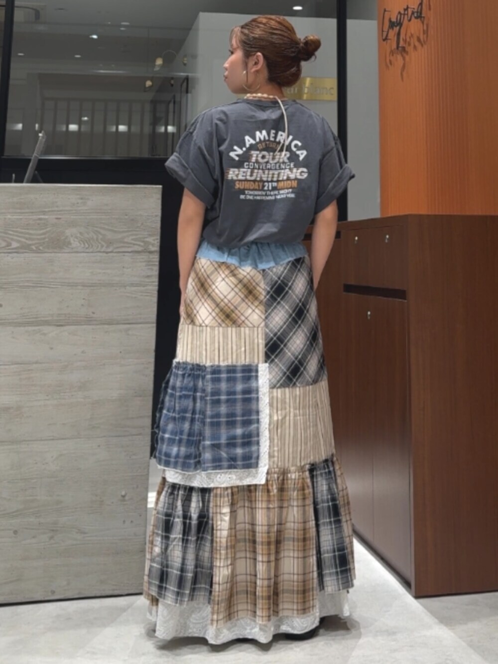 グレー系のTシャツ/カットソー、ブラック系のサンダル、その他のスカートを着用したレディースの春コーディネートの4枚目の写真