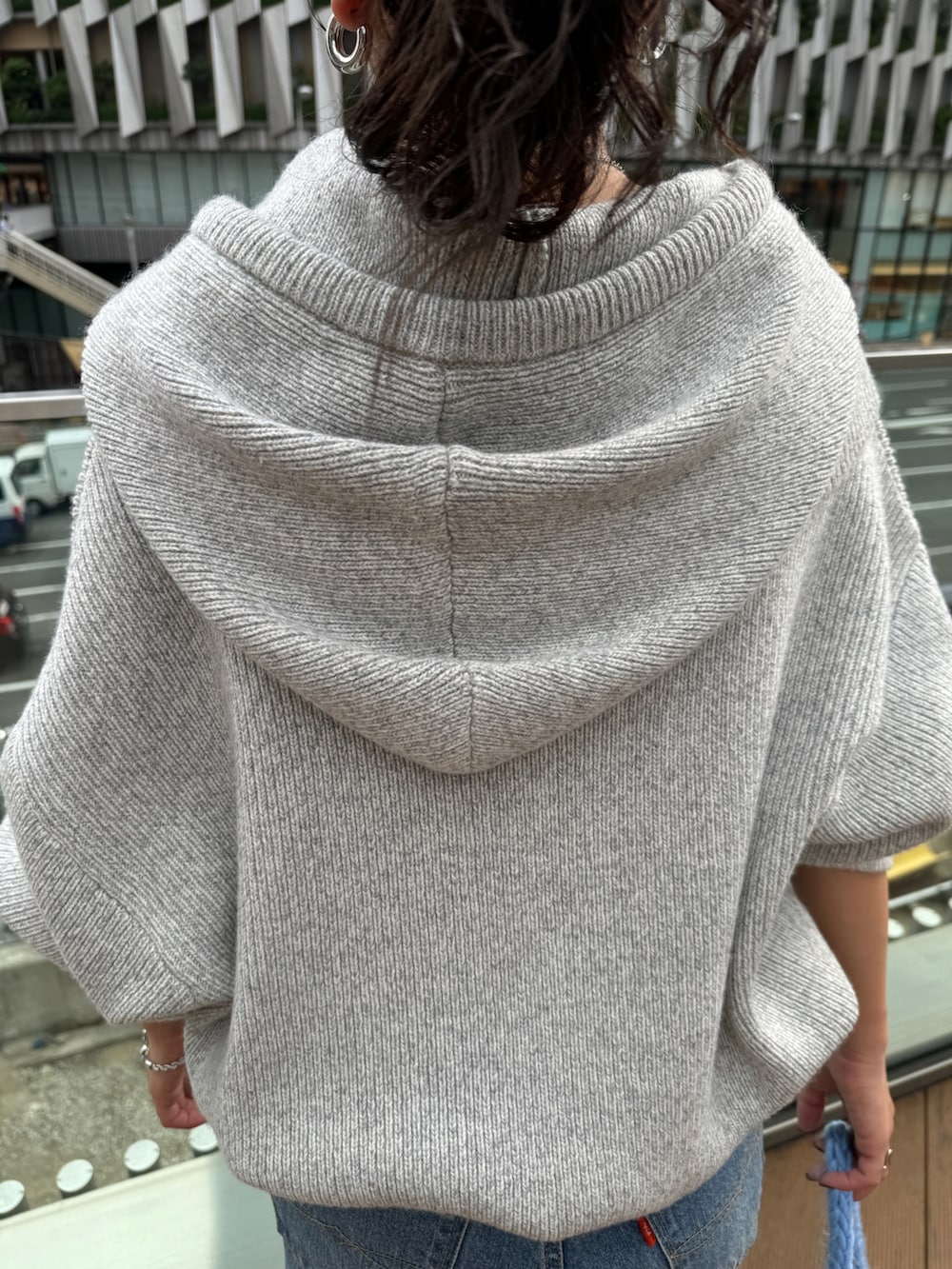 ブルー系のハンドバッグ、グレー系のニット/セーター、ブルー系のデニムパンツを着用したレディースの秋コーディネートの6枚目の写真