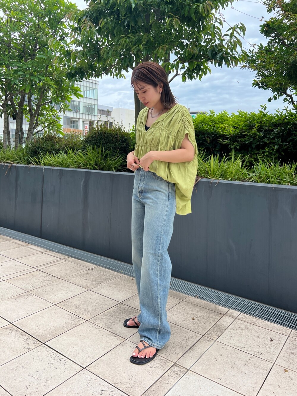 グリーン系のシャツ/ブラウス、ブラック系のキャミソール、ブルー系のデニムパンツを着用したレディースの夏コーディネートの3枚目の写真