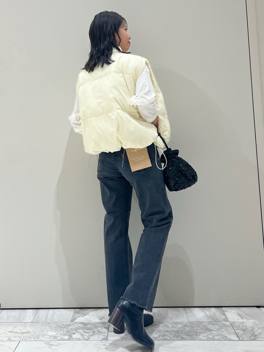 ブラック系のブーツ、ホワイト系のTシャツ/カットソー、ブラック系のデニムパンツを着用したレディースの秋コーディネートの9枚目の写真