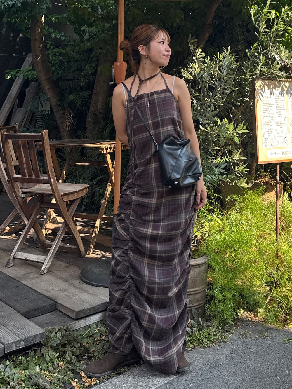 レッド系のワンピース、ブラウン系のブーツを着用したレディースの秋コーディネートの6枚目の写真