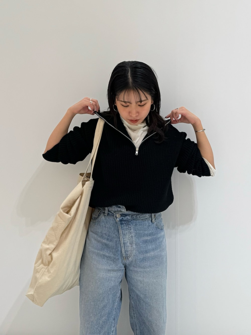 ブルー系のデニムパンツ、ホワイト系のトートバッグ、ホワイト系のTシャツ/カットソーを着用したレディースの冬コーディネートの9枚目の写真