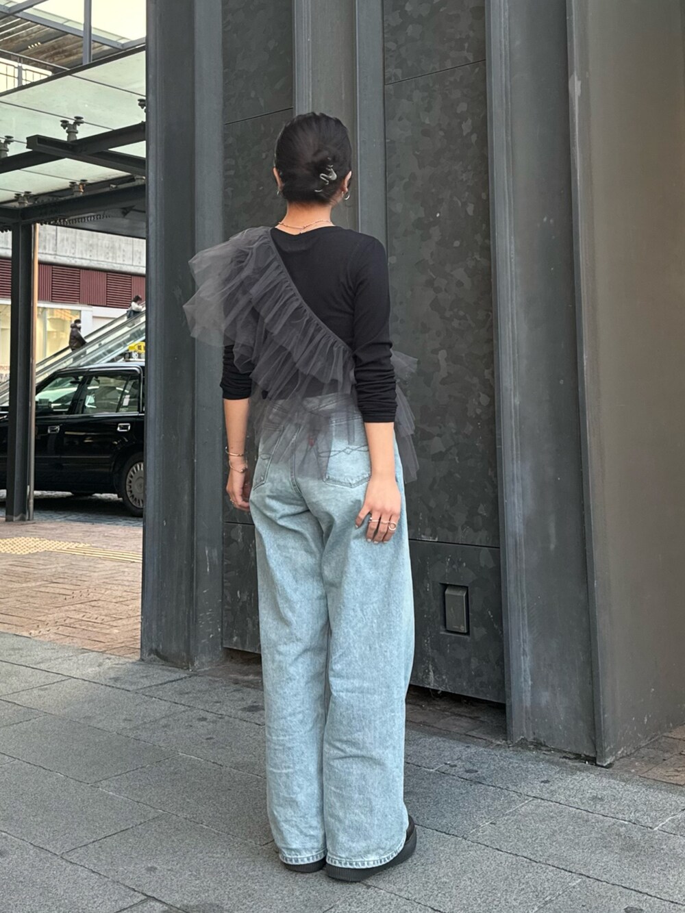 グレー系のベスト、ブラック系のTシャツ/カットソー、ブルー系のデニムパンツを着用したレディースの冬コーディネートの3枚目の写真