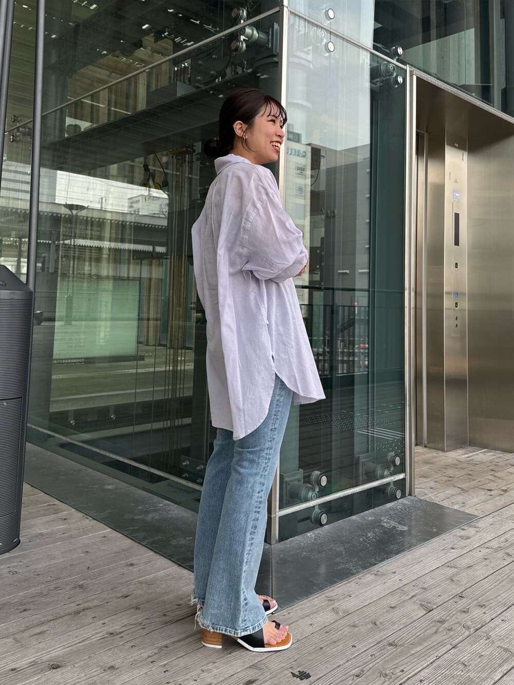 グレー系のTシャツ/カットソー、ブルー系のデニムパンツ、ブラック系のサンダルを着用したレディースの春コーディネートの3枚目の写真