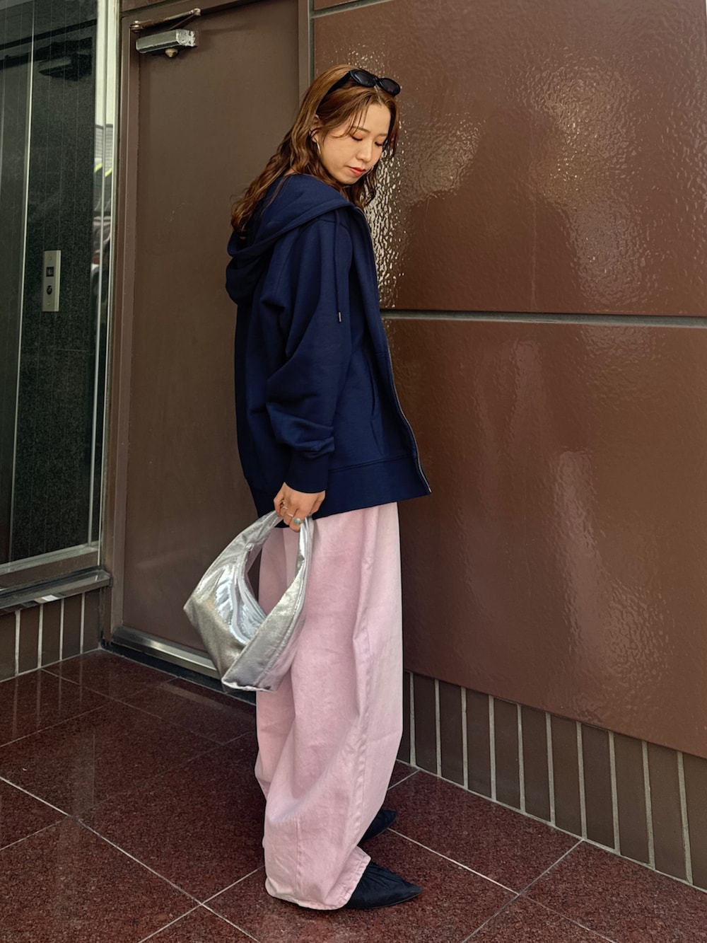 ブルー系のパーカー、ピンク系のデニムパンツ、ブラック系のキャミソールを着用したレディースの春コーディネートの8枚目の写真