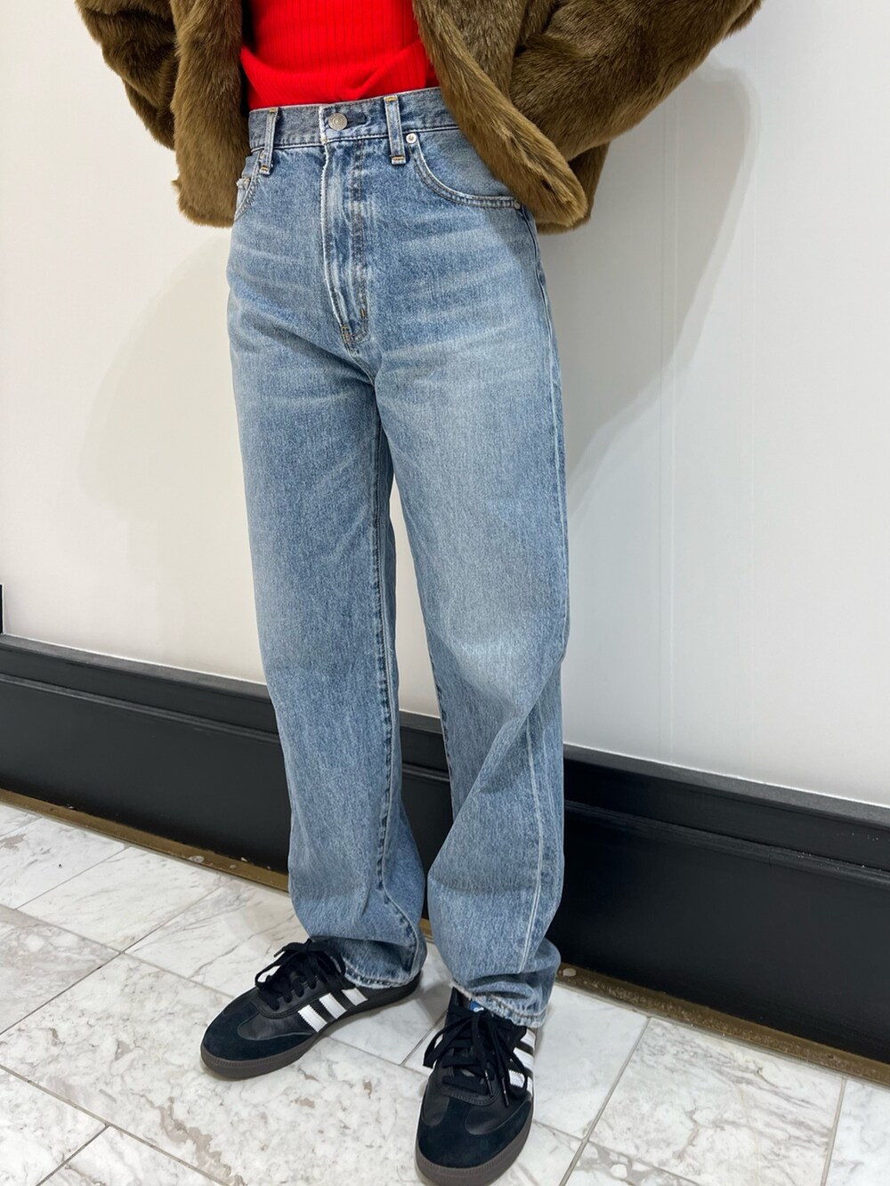 レッド系のニット/セーター、ホワイト系のハンドバッグ、ブルー系のデニムパンツを着用したレディースの冬コーディネートの7枚目の写真