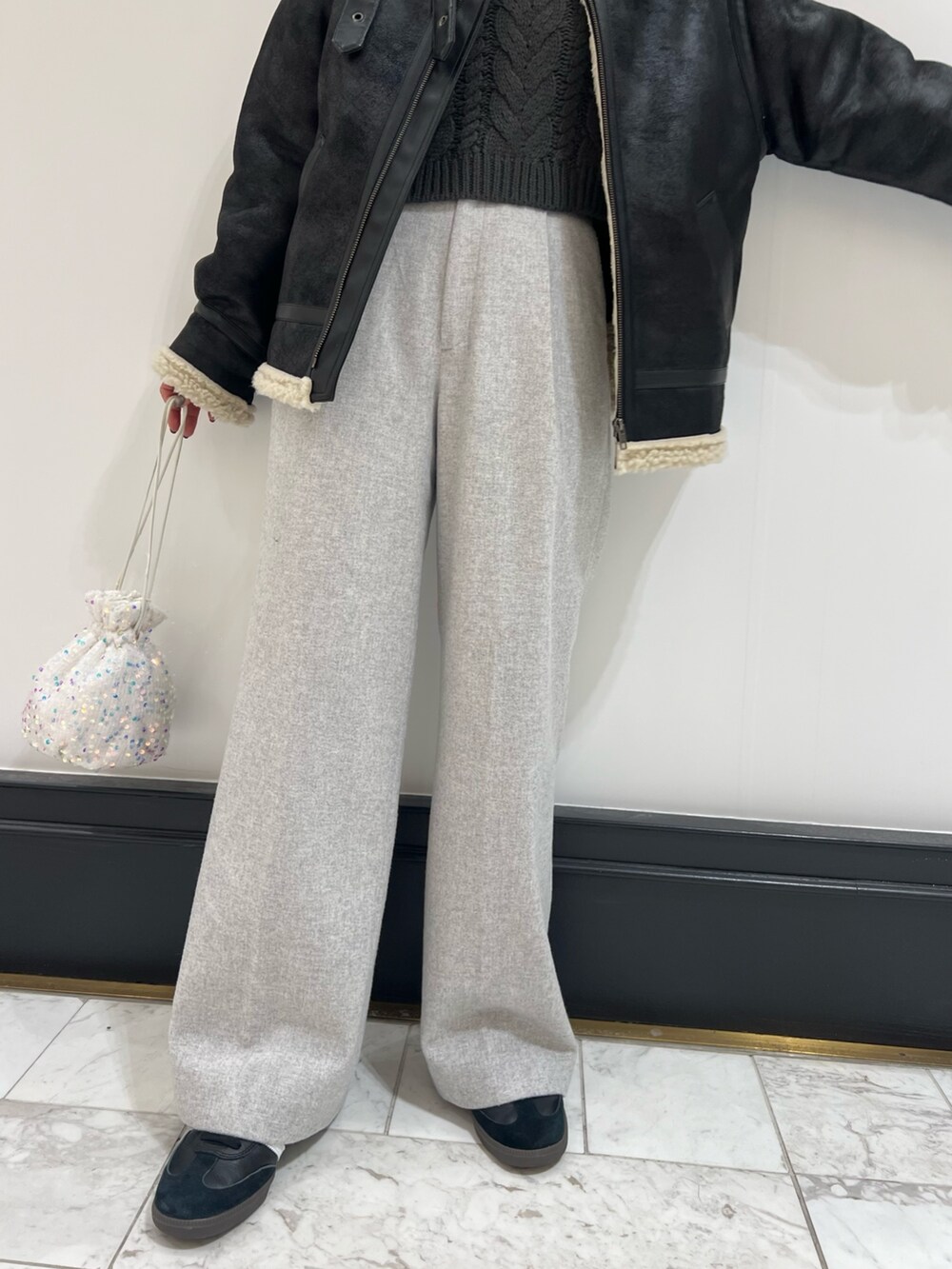 ホワイト系のハンドバッグ、グレー系のニット/セーター、ブラック系のムートンコートを着用したレディースの冬コーディネートの10枚目の写真