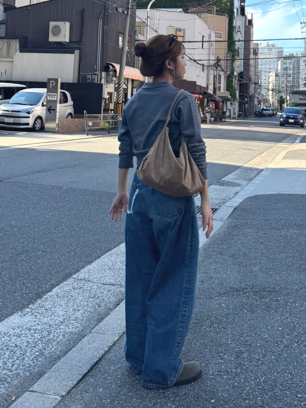 ベージュ系のスリッポン、グレー系のカーディガン/ボレロ、ブルー系のデニムパンツを着用したレディースの夏コーディネートの3枚目の写真