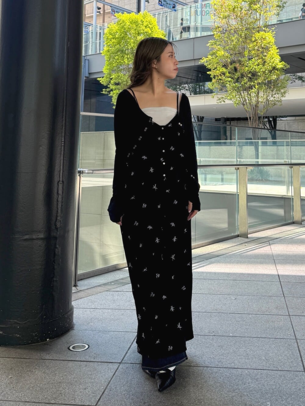 ブルー系のデニムパンツ、ブラック系のパンプス、ブラック系のワンピースを着用したレディースの秋コーディネートの6枚目の写真