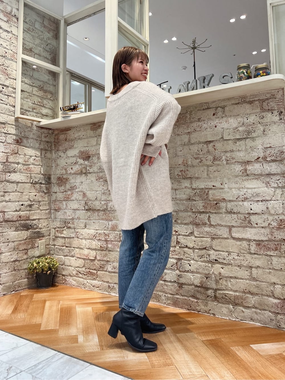ブラック系のブーツ、ブルー系のデニムパンツ、ホワイト系のカーディガン/ボレロを着用したレディースの秋コーディネートの8枚目の写真