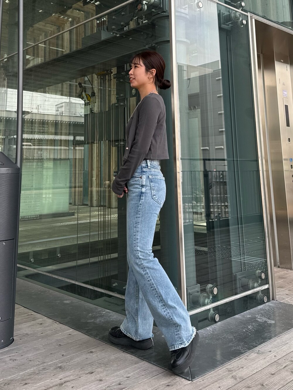 ブルー系のデニムパンツ、グレー系のTシャツ/カットソーを着用したレディースの春コーディネートの3枚目の写真