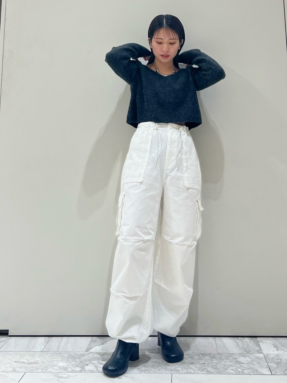 ブラック系のブーツ、ホワイト系のカーゴパンツ、グレー系のニット/セーターを着用したレディースの秋コーディネートの10枚目の写真