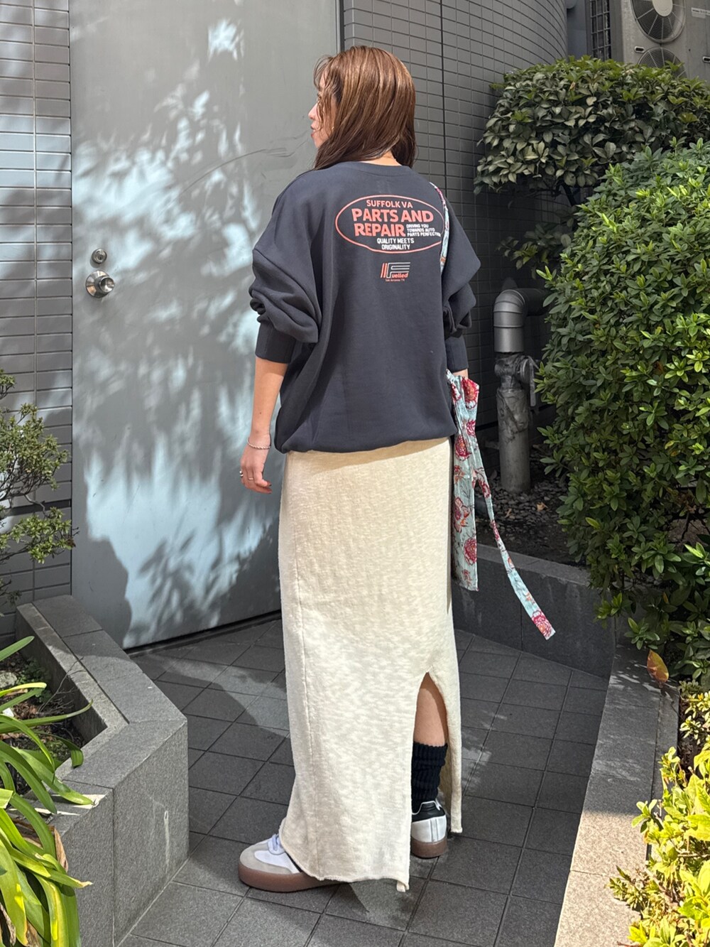 グリーン系のショルダーバッグ、グレー系のスウェット、ホワイト系のスカートを着用したレディースの冬コーディネートの7枚目の写真