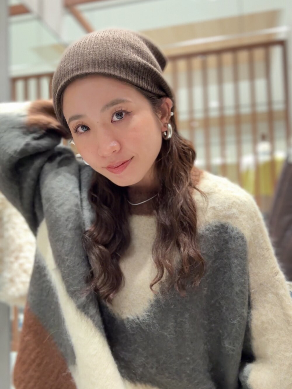 グレー系のニット/セーター、ブラック系のワンピース、ブルー系のデニムパンツを着用したレディースの秋コーディネートの9枚目の写真