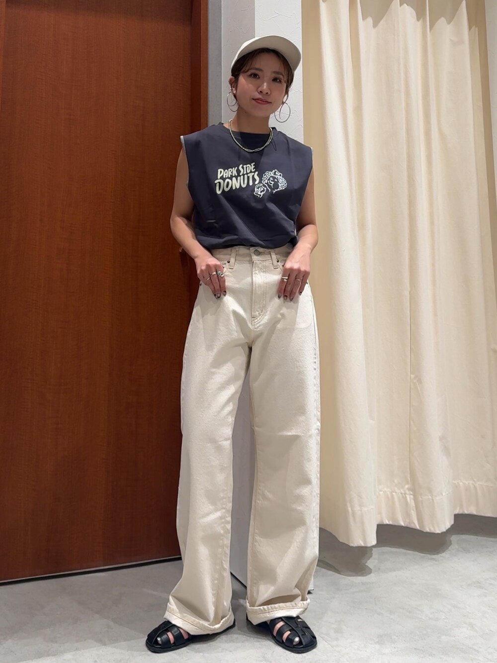 ホワイト系のデニムパンツ、グレー系のタンクトップ、ブラック系のサンダルを着用したレディースの春コーディネートの6枚目の写真