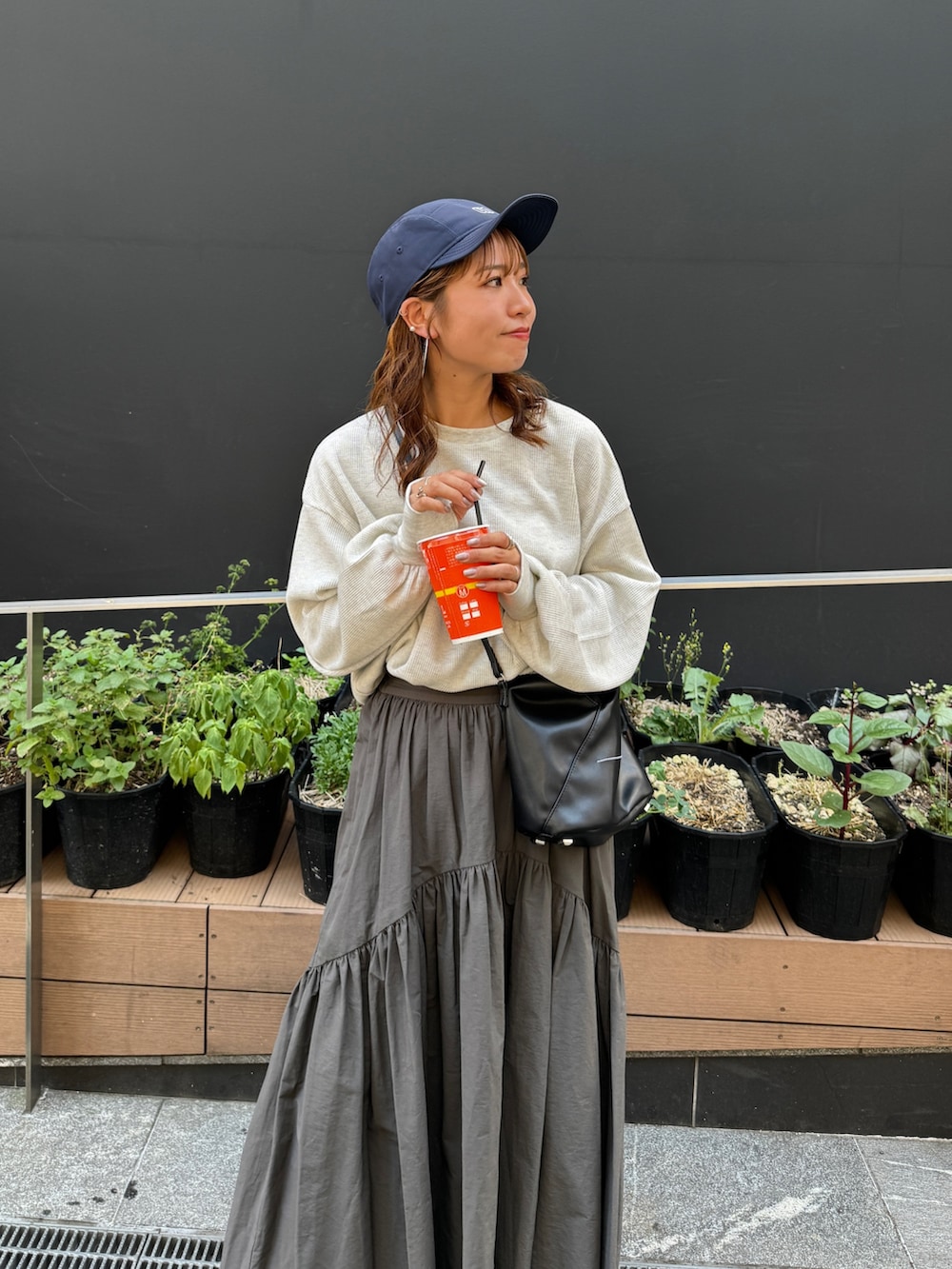 グレー系のスカート、ホワイト系のTシャツ/カットソー、ブルー系のキャップを着用したレディースの夏コーディネートの6枚目の写真