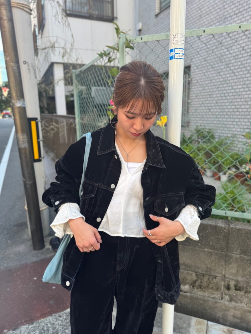 ブラック系のスリッポン、ブラック系のデニムパンツ、ブルー系のトートバッグを着用したレディースの夏コーディネートの6枚目の写真