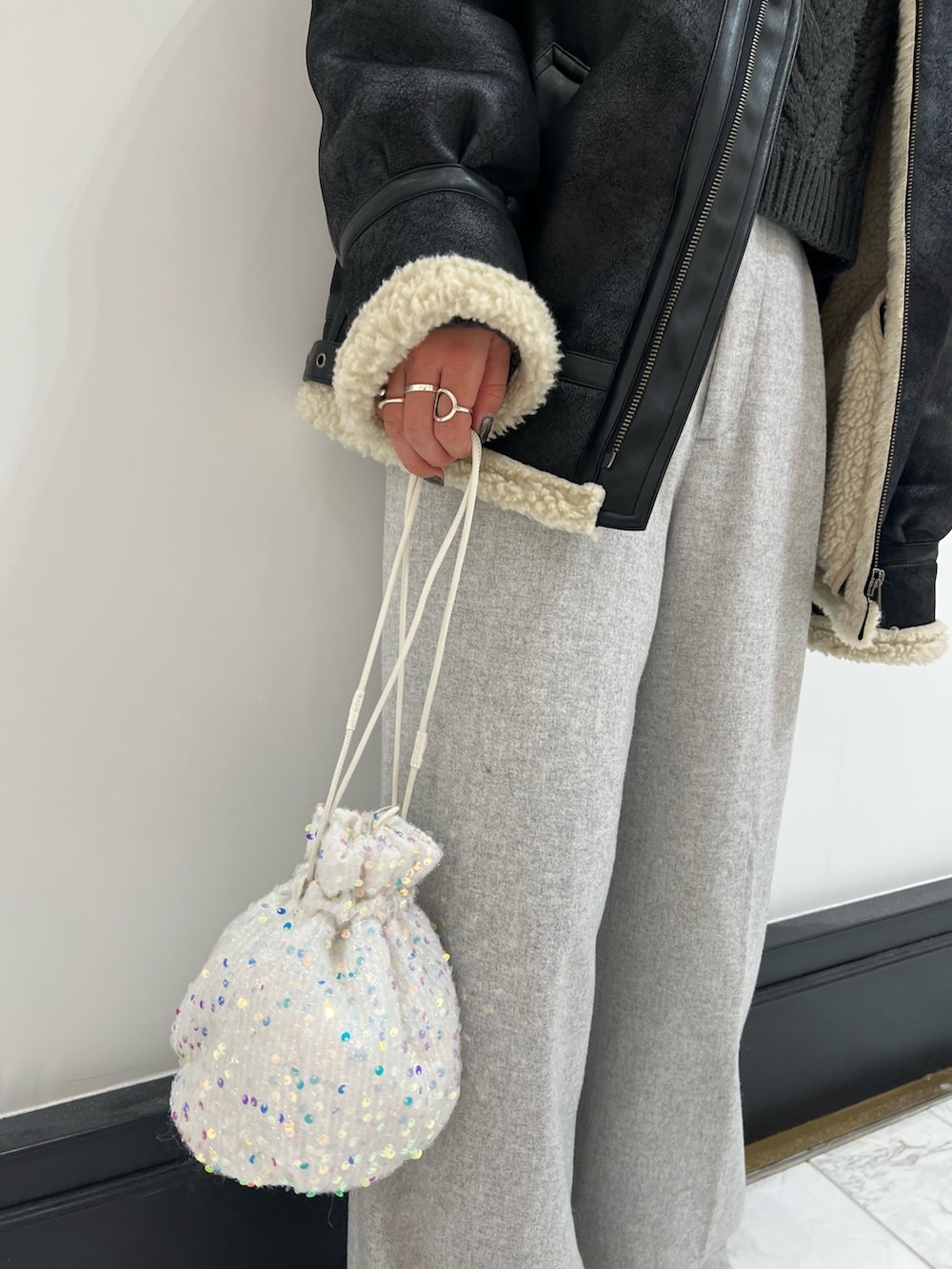 グレー系のその他パンツ、グレー系のニット/セーター、ホワイト系のハンドバッグを着用したレディースの冬コーディネートの8枚目の写真