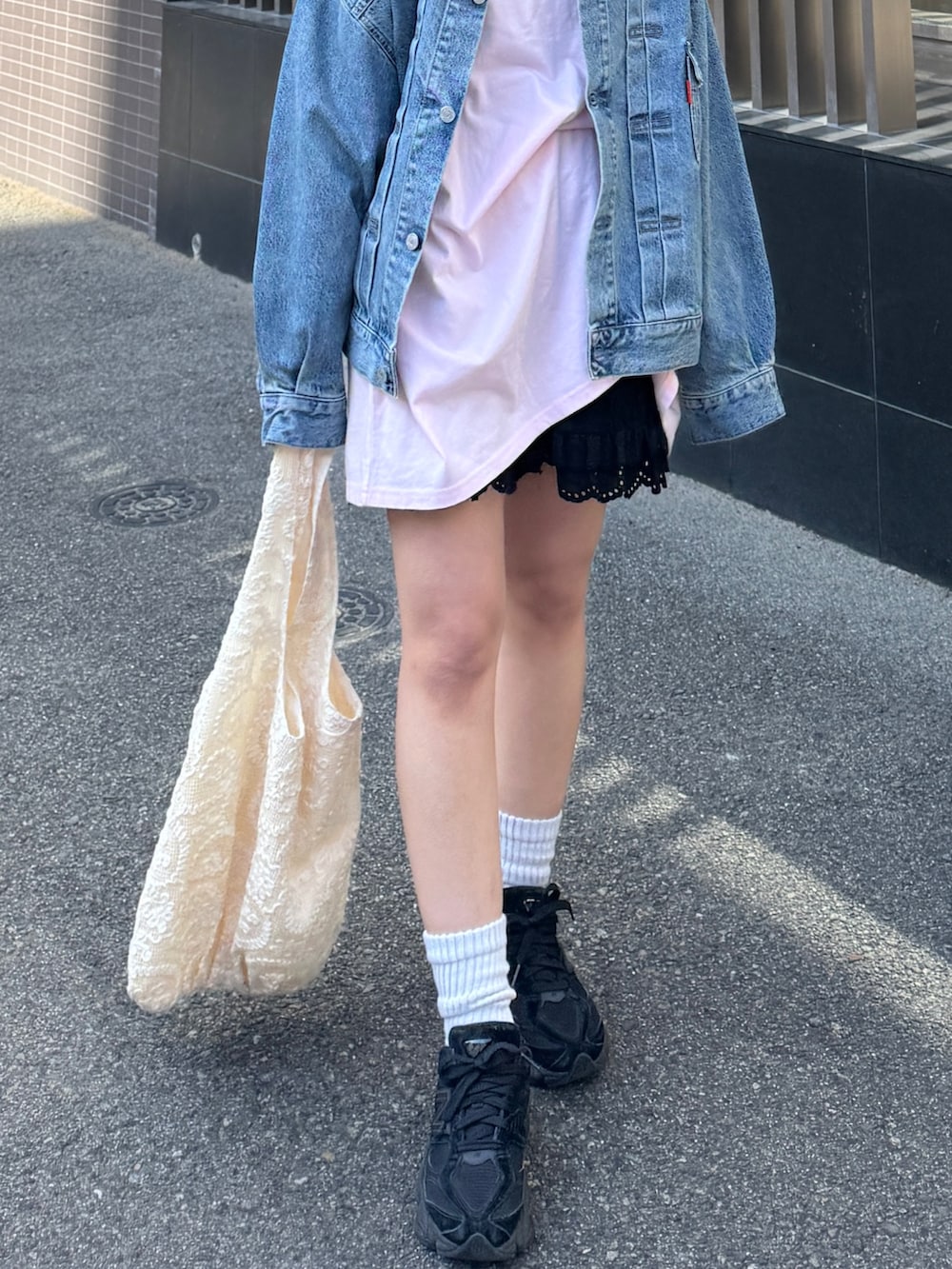 ピンク系のTシャツ/カットソー、ブルー系のデニムジャケット、ブラック系のその他パンツを着用したレディースの春コーディネートの4枚目の写真