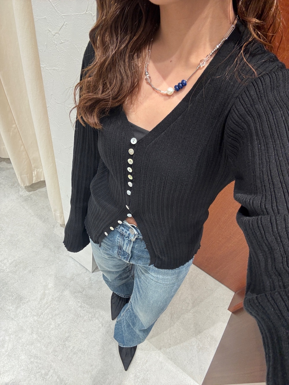 ブルー系のデニムパンツ、ブラック系のカーディガン/ボレロ、ブラック系のパンプスを着用したレディースの春コーディネートの8枚目の写真