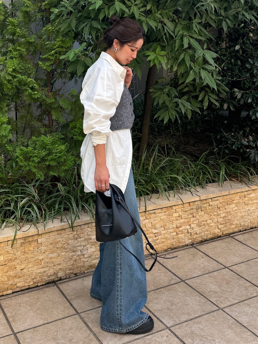 ブルー系のデニムパンツ、ホワイト系のシャツ/ブラウス、ブラック系のニット/セーターを着用したレディースの秋コーディネートの4枚目の写真