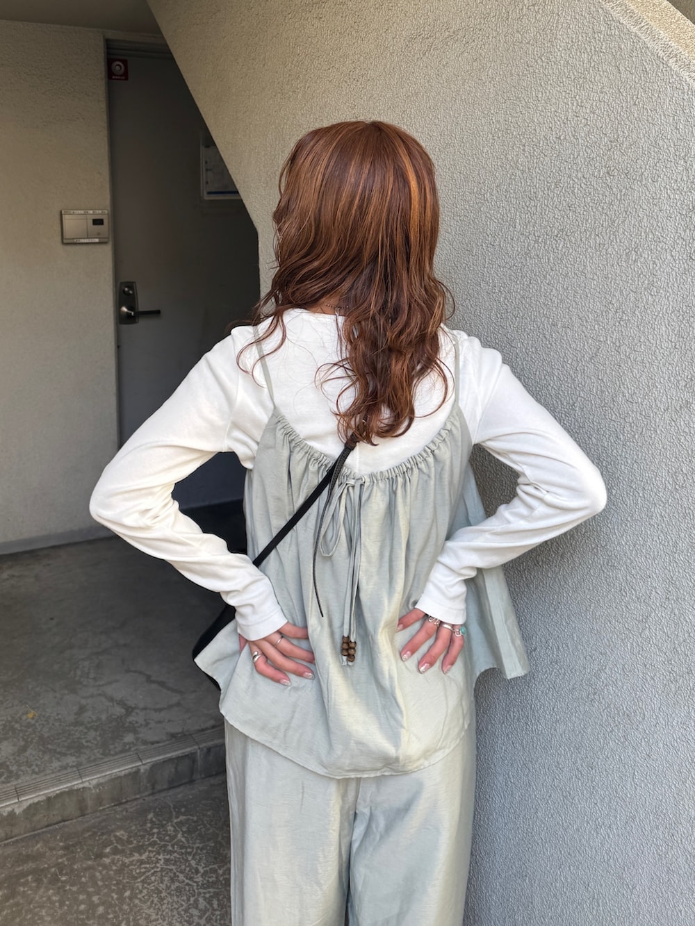 ブルー系のデニムジャケット、ホワイト系のTシャツ/カットソー、グリーン系のキャミソールを着用したレディースの冬コーディネートの8枚目の写真