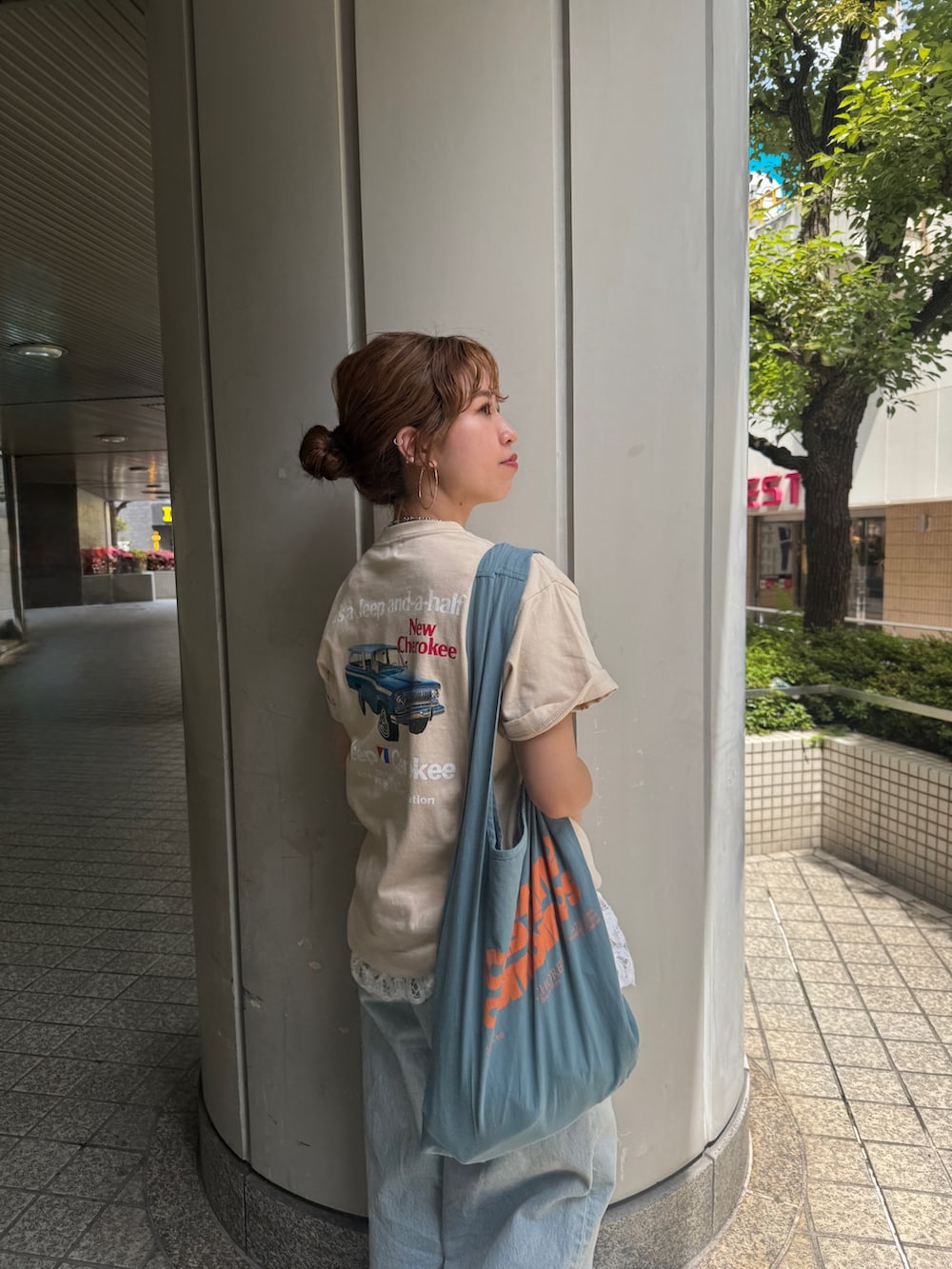 ブルー系のデニムパンツ、ブルー系のトートバッグ、ホワイト系のシャツ/ブラウスを着用したレディースの夏コーディネートの7枚目の写真