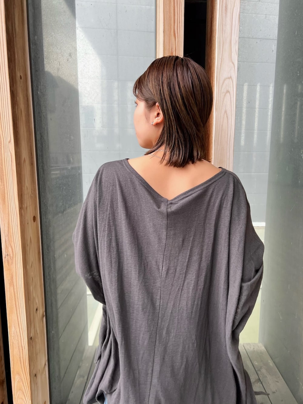 グレー系のTシャツ/カットソー、ブルー系のデニムパンツ、シルバー系のネックレスを着用したレディースの春コーディネートの10枚目の写真
