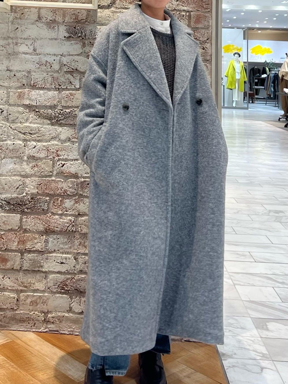 グレー系のニット/セーター、ブルー系のデニムパンツ、ブラック系のローファーを着用したレディースの秋コーディネートの7枚目の写真