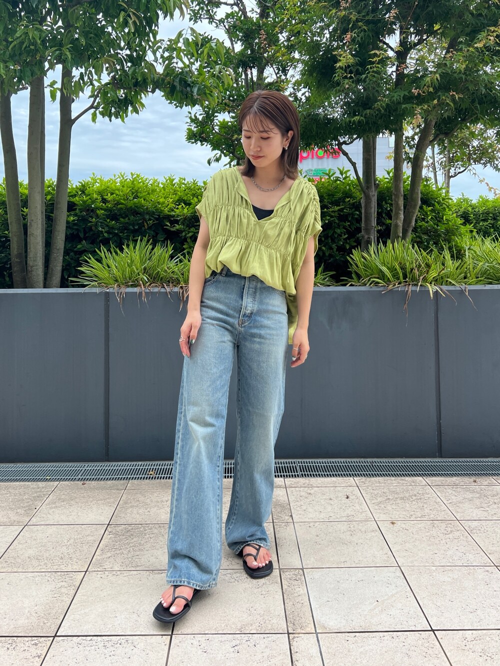 グリーン系のシャツ/ブラウス、ブラック系のキャミソール、ブルー系のデニムパンツを着用したレディースの夏コーディネートの2枚目の写真