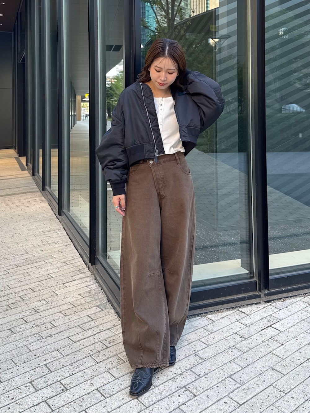 ブラウン系のデニムパンツ、ホワイト系のTシャツ/カットソー、ブラック系のMA-1を着用したレディースの秋コーディネートの2枚目の写真