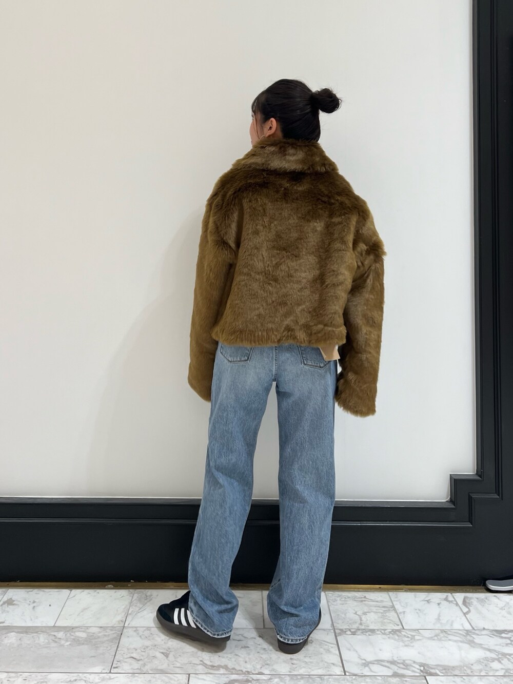 ブルー系のデニムパンツ、ブラウン系のブルゾン、レッド系のニット/セーターを着用したレディースの冬コーディネートの9枚目の写真