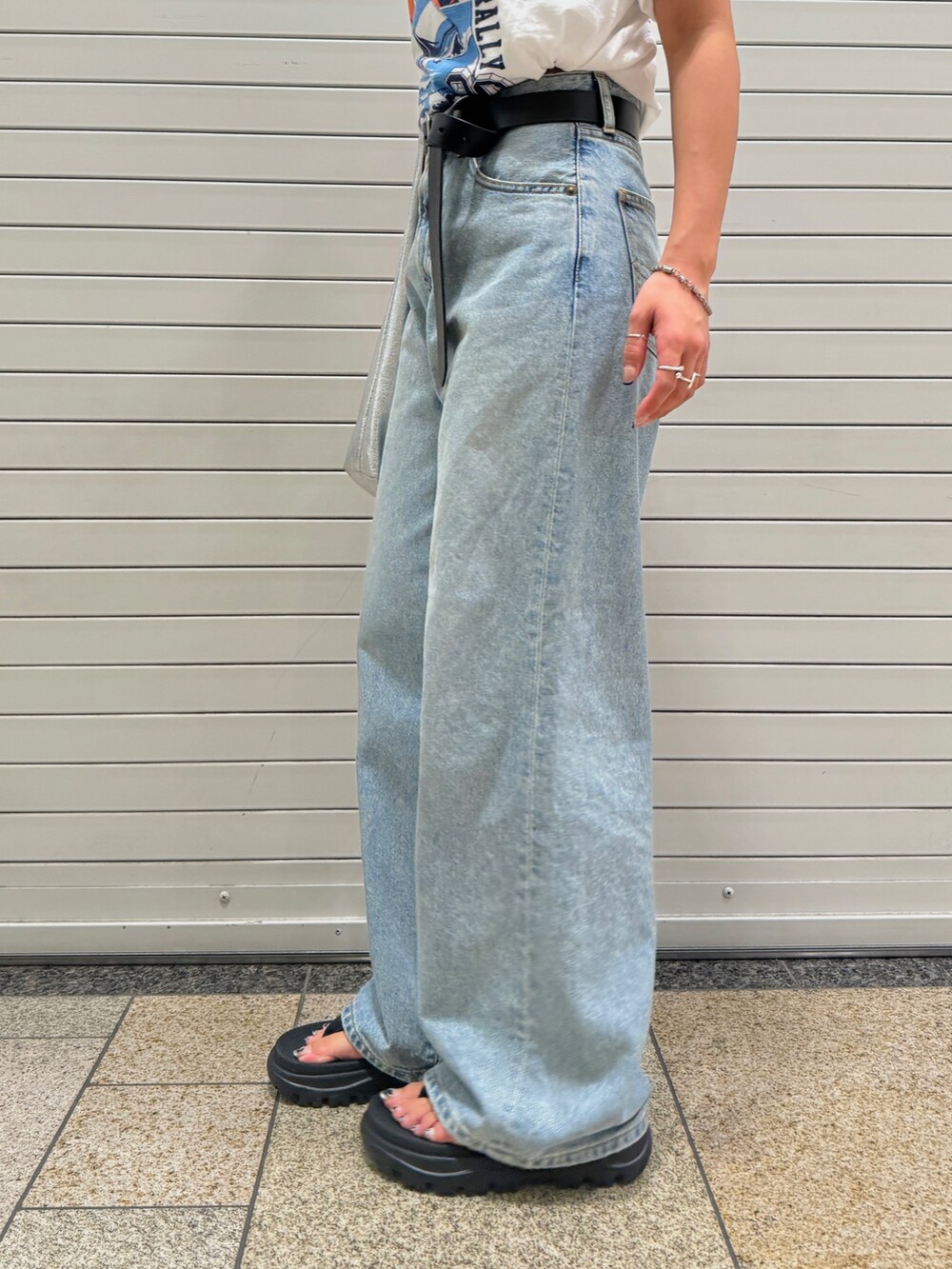 ブルー系のデニムパンツ、ホワイト系のTシャツ/カットソー、ブラック系のベルトを着用したレディースの夏コーディネートの10枚目の写真