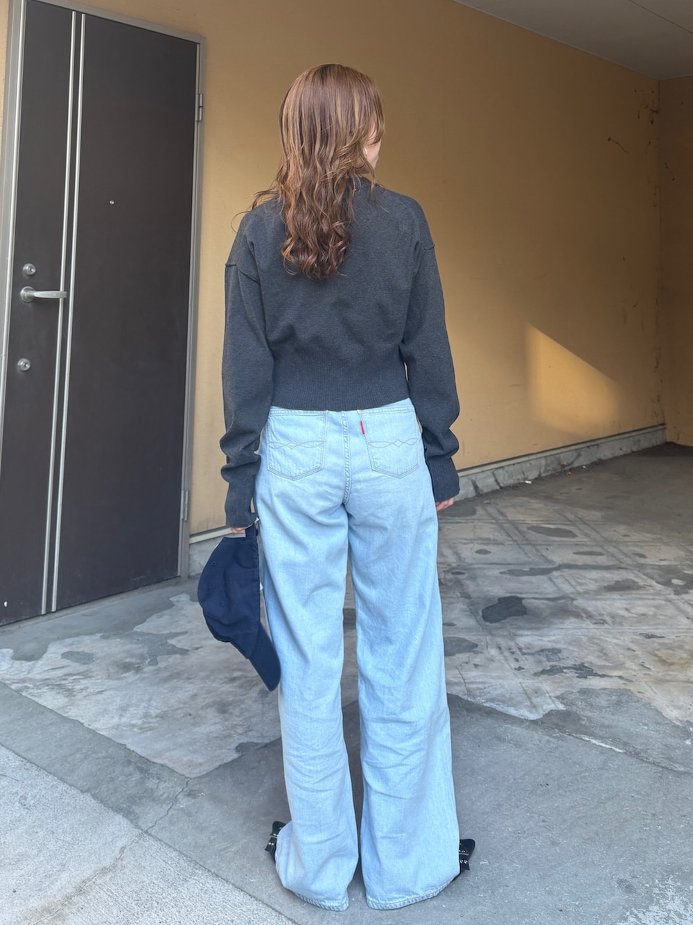 グレー系のカーディガン/ボレロ、ブルー系のデニムパンツを着用したレディースの春コーディネートの5枚目の写真