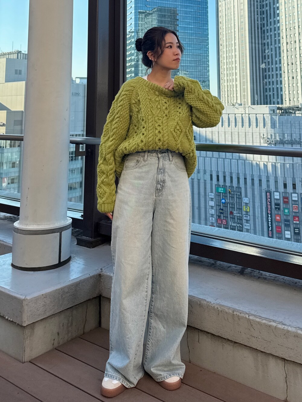 グリーン系のニット/セーター、ホワイト系のTシャツ/カットソー、ブルー系のデニムパンツを着用したレディースの冬コーディネートの8枚目の写真