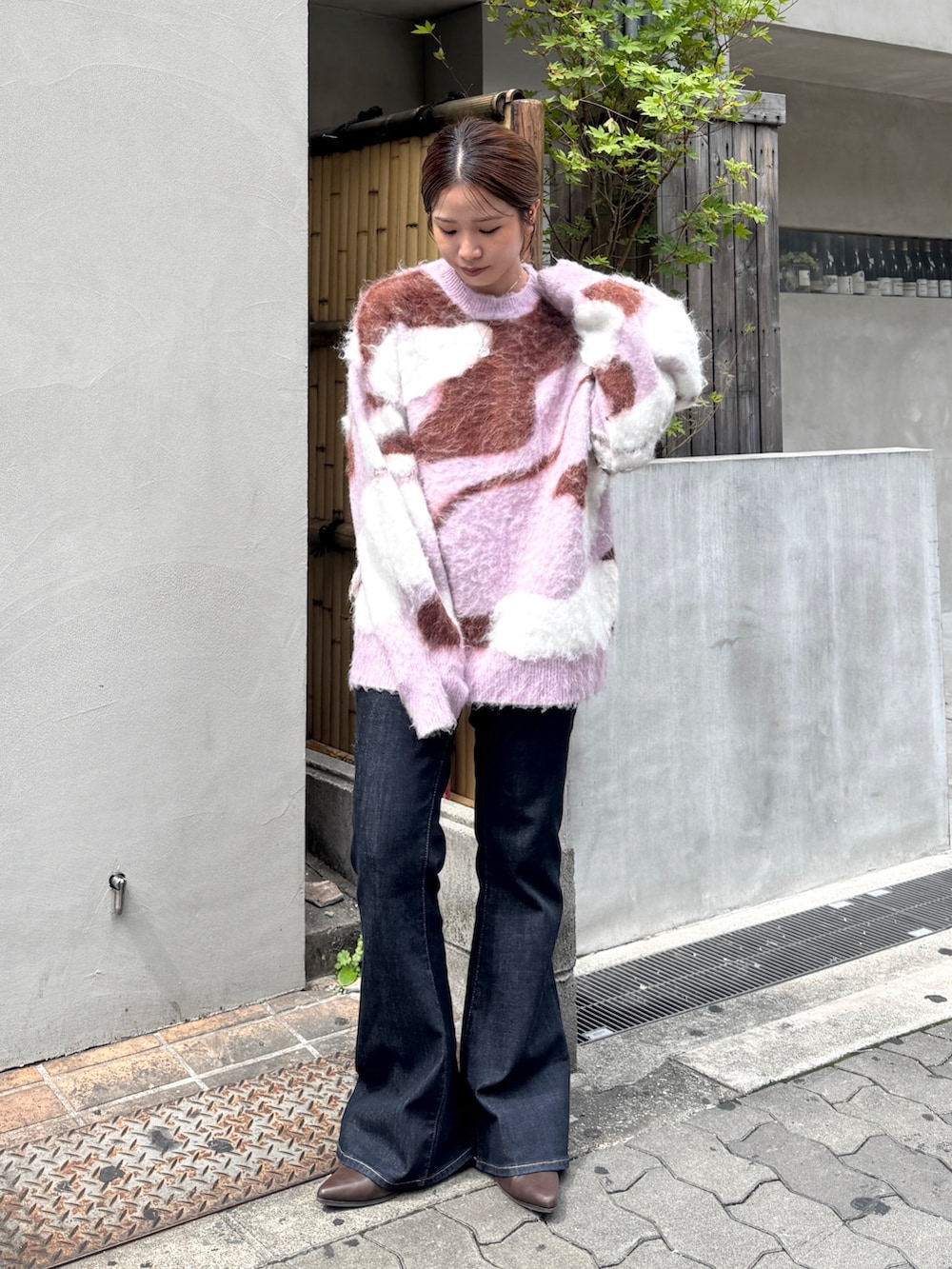 ブルー系のデニムパンツ、ブラウン系のブーツ、ピンク系のニット/セーターを着用したレディースの秋コーディネートの5枚目の写真