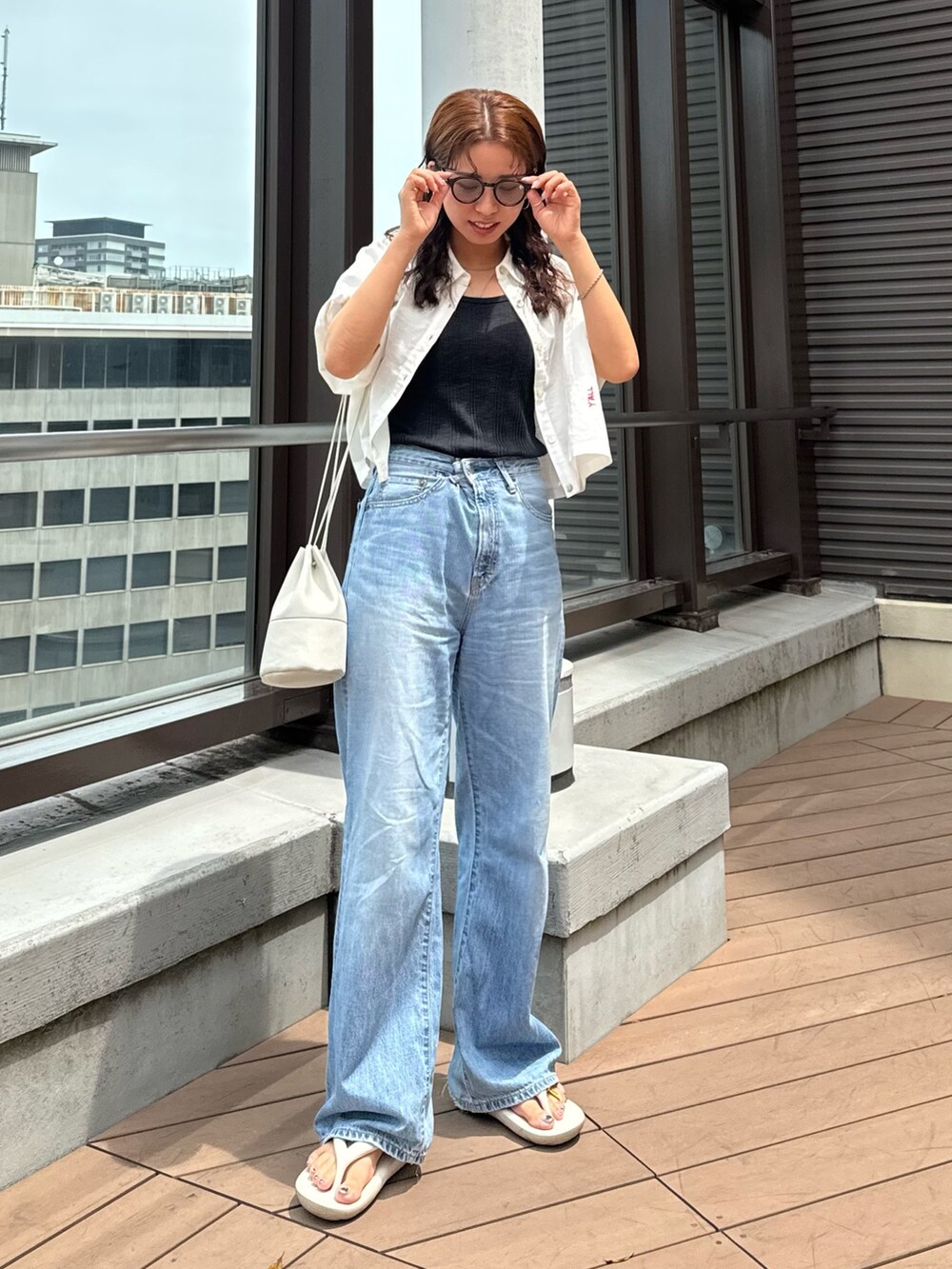 ブルー系のデニムパンツ、グレー系のTシャツ/カットソー、ホワイト系のシャツ/ブラウスを着用したレディースの夏コーディネートの3枚目の写真